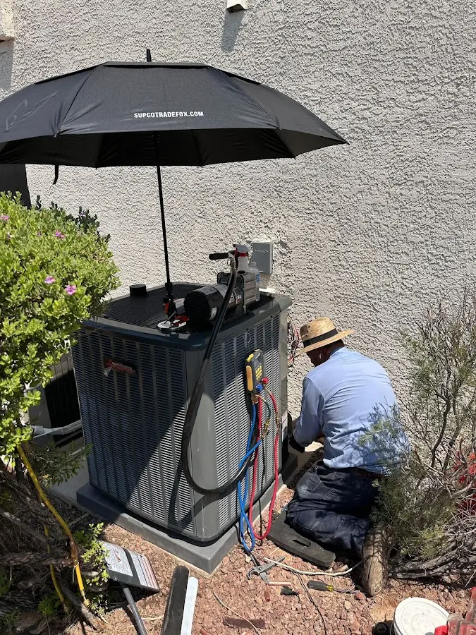 HVAC technician performing outdoor AC maintenance in Clarinda