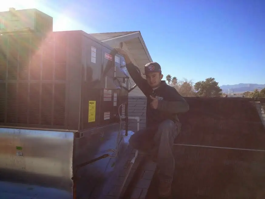 HVAC technician performing Boiler Repair on a rooftop unit in Clarinda
